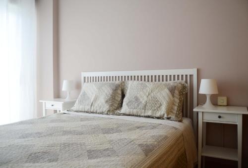 sypialnia z łóżkiem z białą narzutą i poduszkami w obiekcie Apartamento Ana w mieście Portonovo