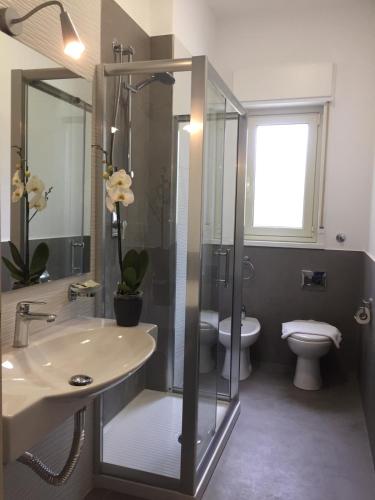 a bathroom with a shower and a sink and a toilet at Baia Del Sole in Licata