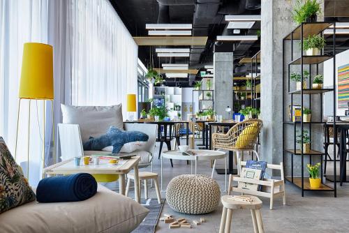 a living room with chairs and tables and a table at Hotel Arche Geologiczna in Warsaw
