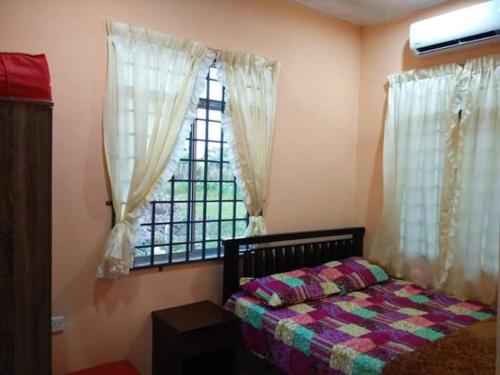 een slaapkamer met een bed voor een raam bij HOMESTAY AQILAH PASIR PUTEH KELANTAN in Pasir Puteh
