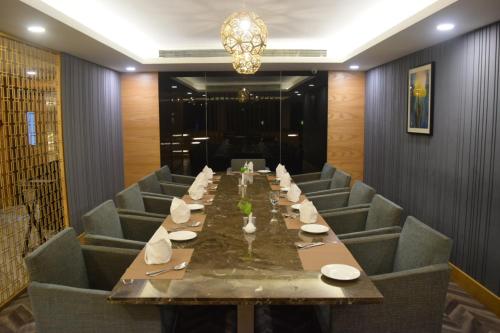 a long dining room with a long table and chairs at Country Inn & Suites By Radisson Jammu in Jammu