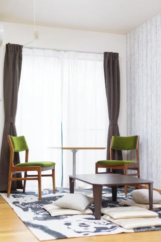 a living room with two chairs and a table at Hummingbird Kanazawa in Kanazawa