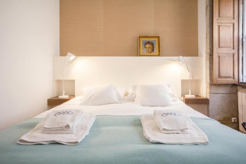 a bedroom with a bed with two towels on it at Porto Premium River View II in Porto