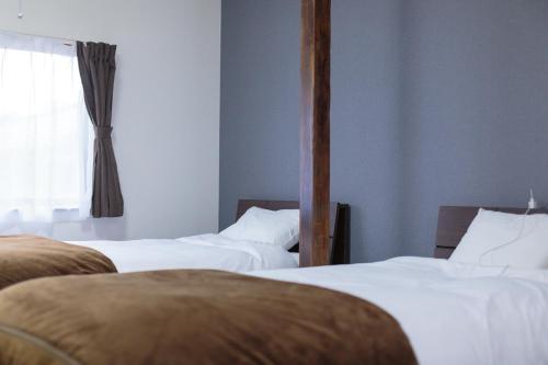 a room with two beds and a window at Hummingbird Kanazawa in Kanazawa