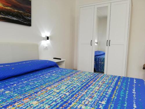 a bedroom with a bed with a blue comforter at Appartamento Le Magnolie 2 in Mestre