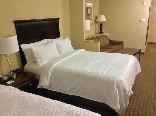 a hotel room with two beds and a chair at Comfort Suites Mobile-South Alabama University Area in Mobile