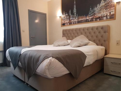 Hôtel Méribel في بروكسل: غرفة نوم مع سرير كبير مع سيد سرير كبير