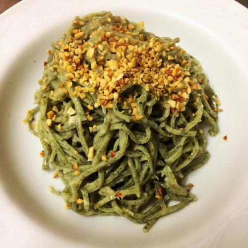 a plate of green pasta withesame seeds on it at Agriturismo Cà Trinche in Camo