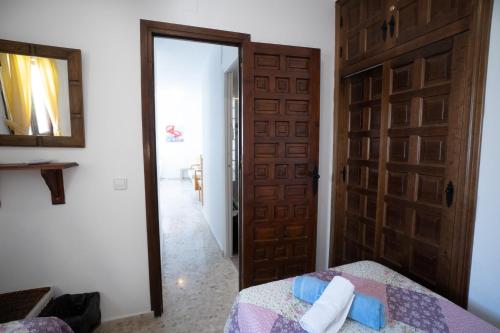 ネルハにあるUrb.Punta Lara, Plza. Sevilla 2, 1Dのベッドルーム1室(ドア、ベッド、鏡付)