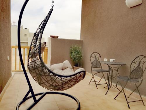 a swing chair in a living room with a table at Tslil Suite in Yeroẖam