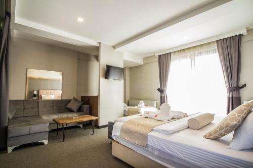 Habitación de hotel con 2 camas y sofá en Hit Suites Avcilar Hotel, en Avcılar