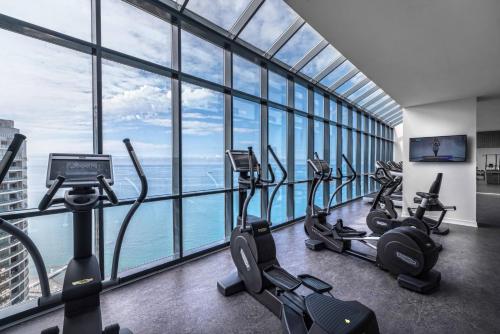 a gym with treadmills and ellipticals in a building with windows at Mercure Sochi Centre Hotel in Sochi