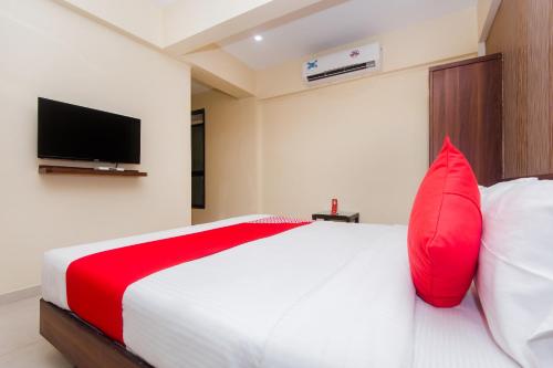 a bedroom with a bed with a red pillow and a tv at Hotel Park Inn in Vasai