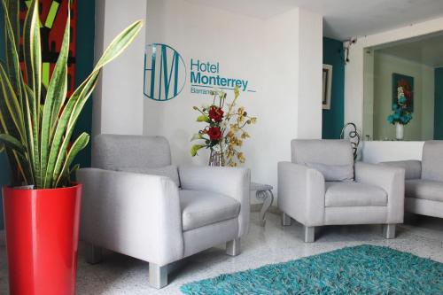 a waiting room with chairs and a potted plant at Hotel Monterrey in Barranquilla