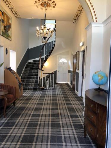 a hallway with a staircase with a chandelier at Park View House in Edinburgh