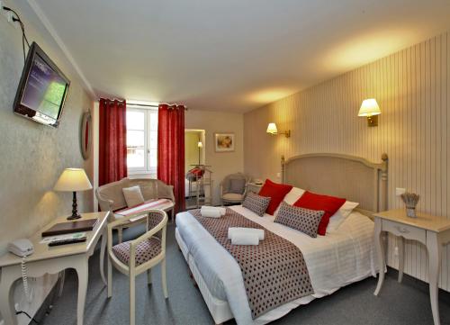 um quarto de hotel com uma cama grande e uma secretária em Hôtel Le Madrigal em Sarlat-la-Canéda