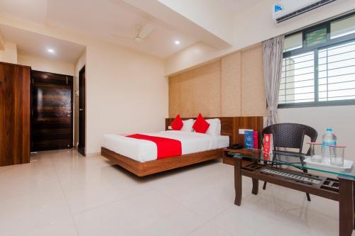 a bedroom with a bed and a desk and a keyboard at Hotel Park Inn in Vasai