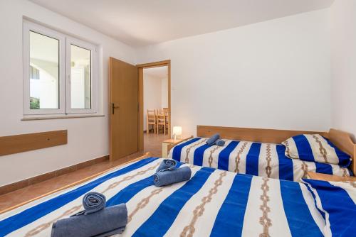 a bedroom with two beds and a window at Apartment in pinewood near the sea in Nerezine