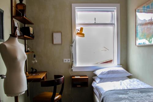a bedroom with a bed and a desk and a window at Hotel Siglunes in Siglufjörður