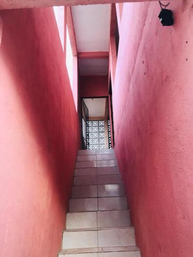 a stairway with a red wall and a red stair case at Casa de Veraneio Ilha de Itamaracá in Itamaracá