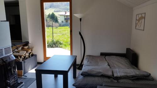 a bedroom with a bed and a table and a window at Domek Pod Brzozami in Świnna