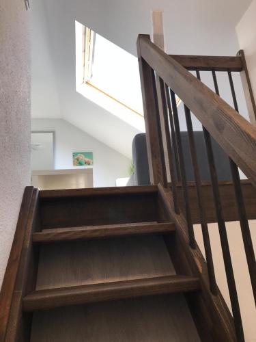 a wooden staircase in a room with a window at Wohnen am Wanderweg in Aurich