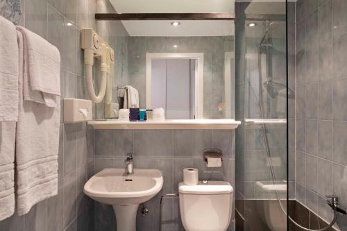 a bathroom with a sink and a toilet and a shower at Argus Hotel Brussels in Brussels