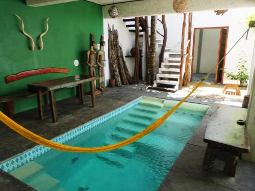 a swimming pool with a yellow hose around it at Pousada O Refúgio in Jericoacoara