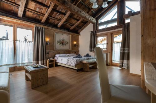 a bedroom with a bed in a room with windows at La Grolla Rooms & Apartments in Livigno