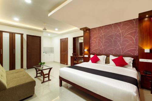 1 dormitorio con 1 cama grande y 1 sofá en Burooj Hotel en Kochi