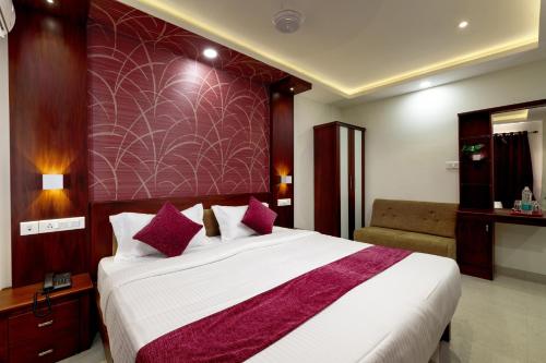 a bedroom with a large bed with a purple wall at Burooj Hotel in Cochin