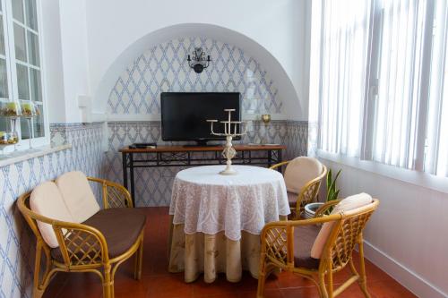 a dining room with a table and chairs and a tv at Hospedaria Os Condes in Reguengos de Monsaraz