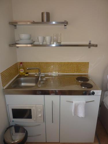 a small kitchen with a sink and a microwave at WynnStay Studio Apartments in Southend-on-Sea