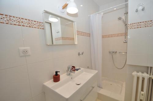 a white bathroom with a sink and a shower at 9 Rue Buttura in Cannes