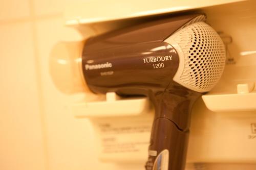a hair dryer sitting on top of a shelf at Resorpia Beppu in Beppu