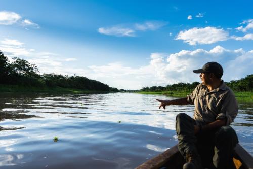 a man sitting in a boat on a river at Ämak Iquitos Ecolodge - All Inclusive in Santa Clara