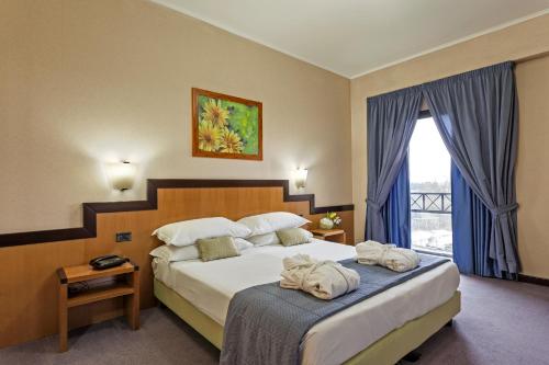 ein Hotelzimmer mit einem Bett mit Handtüchern darauf in der Unterkunft Hotel Olimpia in Avezzano