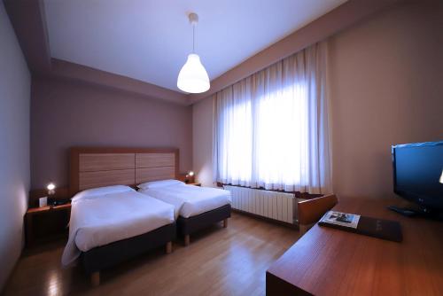 a hotel room with a bed and a television at Monica Hotel Fiera in Pregnana Milanese