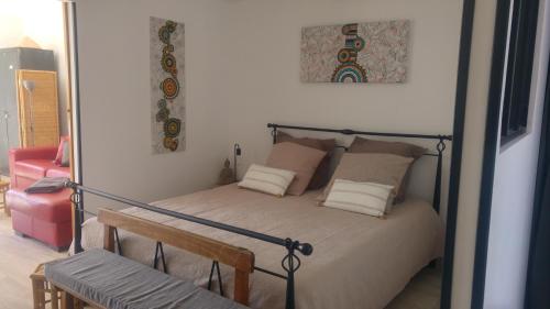 Dormitorio con cama con banco y espejo en gite LAPAZ/jacuzzi privé/piscine, en Draguignan