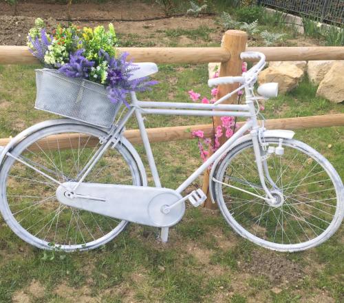 een witte fiets geparkeerd naast een hek met bloemen bij B&B Casa Giorgia in Campobasso