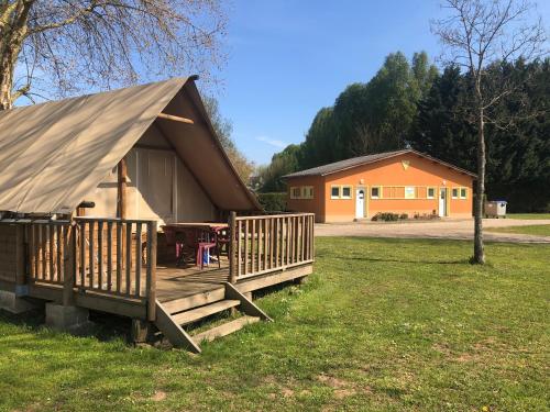 a cabin with a porch and a house at Camping Arquebuse in Auxonne