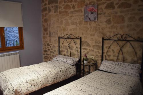 two beds sitting next to each other in a bedroom at Apartamentos La Muralla in Horta de San Joan