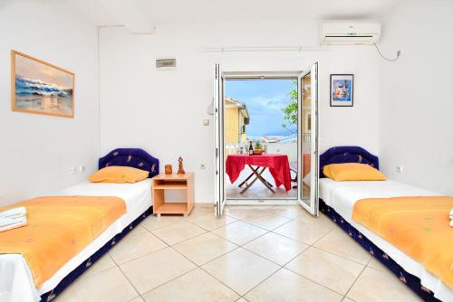 two beds in a room with a table and a mirror at Apartments Porto Bjelila in Tivat