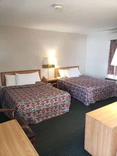 a hotel room with two beds and a table at Budget Inn Horseheads in Horseheads