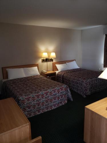 a hotel room with two beds and two lamps at Budget Inn Horseheads in Horseheads