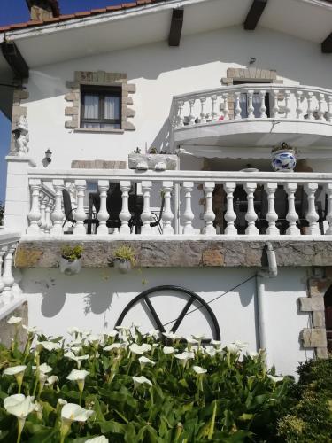 a white house with a balcony and some plants at Agroturismo Pagoederraga in Orio
