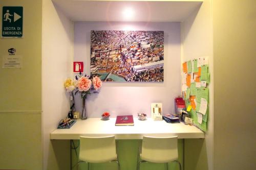 een kamer met een bureau met 2 stoelen en een schilderij bij Colosseoinn in Rome