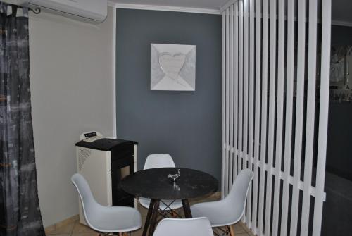 a dining room with a table and white chairs at Nina Apartment in Chania Town