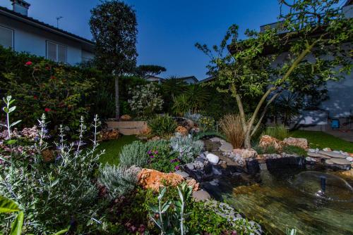 a garden with a pond and many plants at Hotel Tarabella in Forte dei Marmi