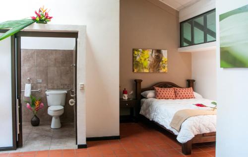 a bedroom with a bed and a toilet at Tapirus Lodge and Reserve in Carrillo